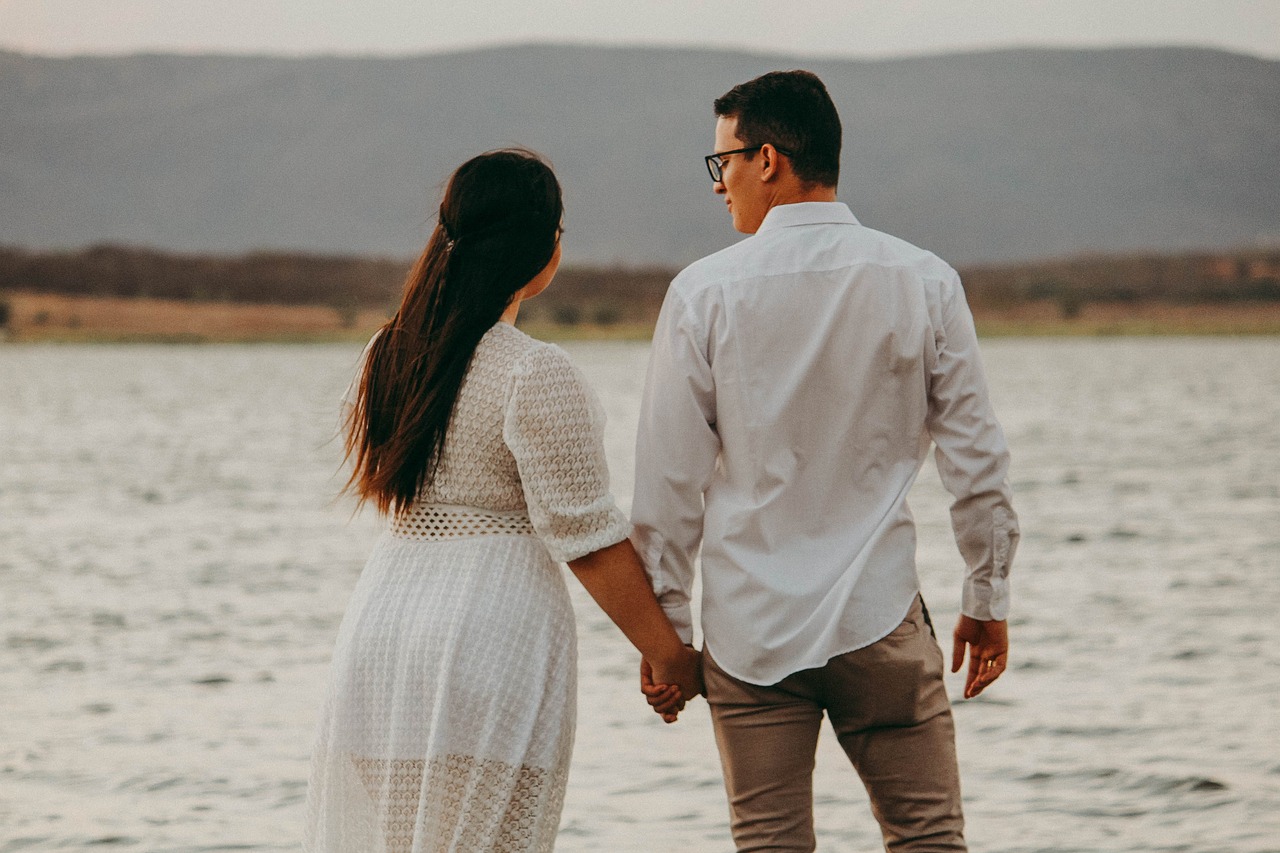 Couple holding hands near water