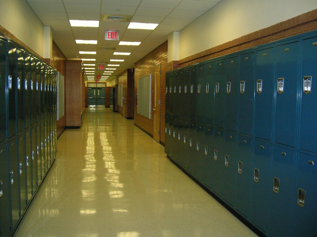 View down an empty high school hallway lined with blue lockers